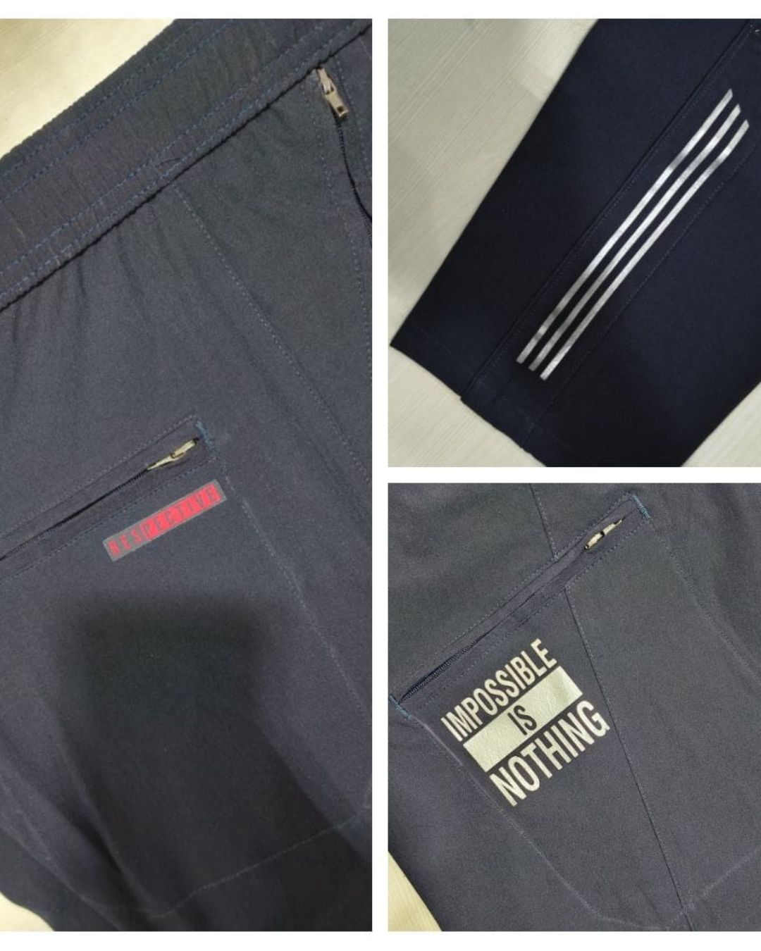 Men's navy blue track pants with zipper pockets, white stripes, and motivational print details.