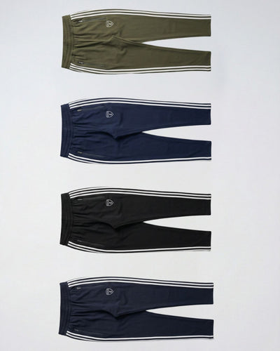 Four men's track pants in olive, navy, black, and blue with white side stripes, flat lay