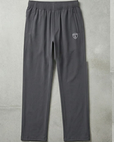 Gray athletic track pants with side pockets and elastic waistband on a concrete background